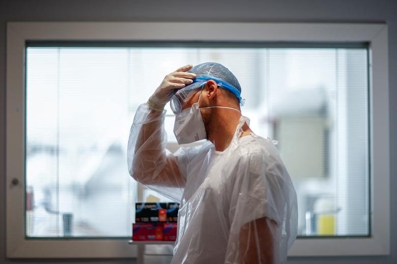 Physiotherapist Adrien adjusts his protective suit as he prepares to treat a patient suffering from the coronavirus in the ICU at the Robert Ballanger hospital in Aulnay-sous-Bois near Paris during the outbreak of the coronavirus disease in France, October 26, 2020. REUTERS/Gonzalo Fuentes